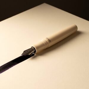 Engrossing No. 8 — A cream acrylic fountain pen with a very broad polished nib laying a wide wet stroke on cream paper.
