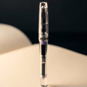 Column Demonstrator — A fully transparent clear acrylic fountain pen showing the dark ebonite feed fins and violet ink inside the converter.