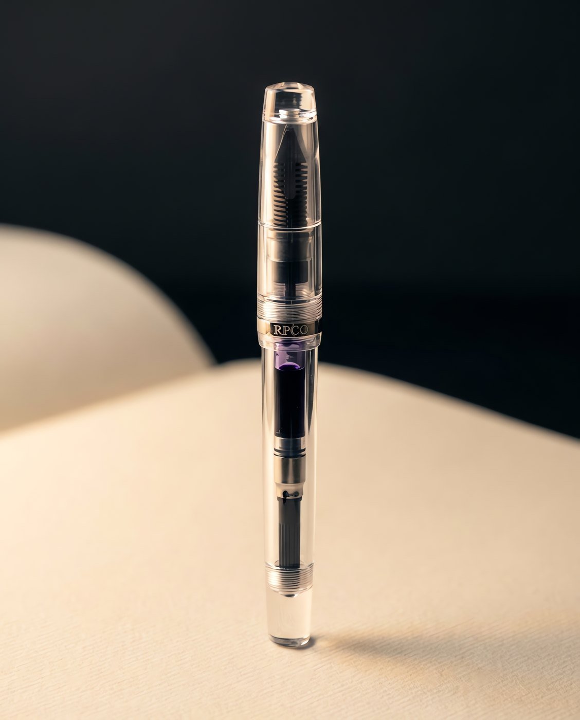 Column Demonstrator — A fully transparent clear acrylic fountain pen showing the dark ebonite feed fins and violet ink inside the converter.