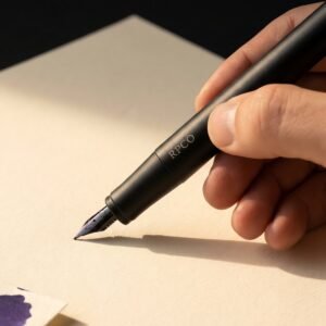 Margin Slim — A very slim matte black anodised aluminium fountain pen with a small fine nib held in a close finger grip.