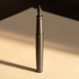 Schoolroom Pen — A sturdy matte charcoal moulded fountain pen with a snap cap and a rounded medium steel nib.