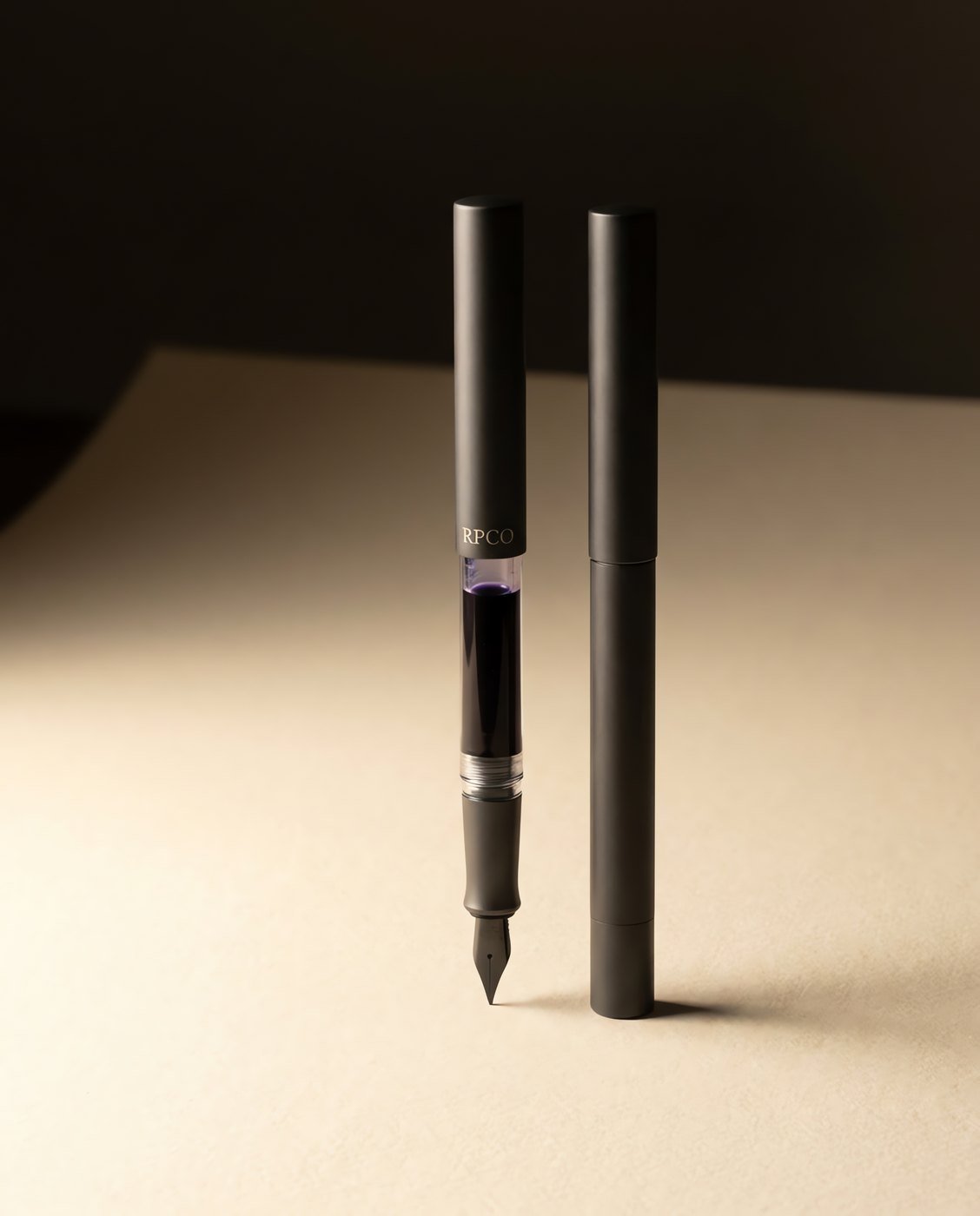 First Entry Pen — A simple charcoal fountain pen with a transparent clear section showing a violet ink cartridge inside.