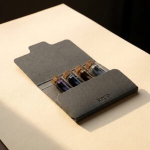 Four-Ink Sample Set — A die-cut card wallet lying open with four small vials of violet, blue-black, brown and grey ink held in place.