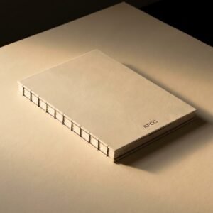 Manuscript Book, Sewn — A limp-bound book with a soft cream vellum-grain wrapper, lying fully open and flat, visible waxed thread stitching along the exposed spine.