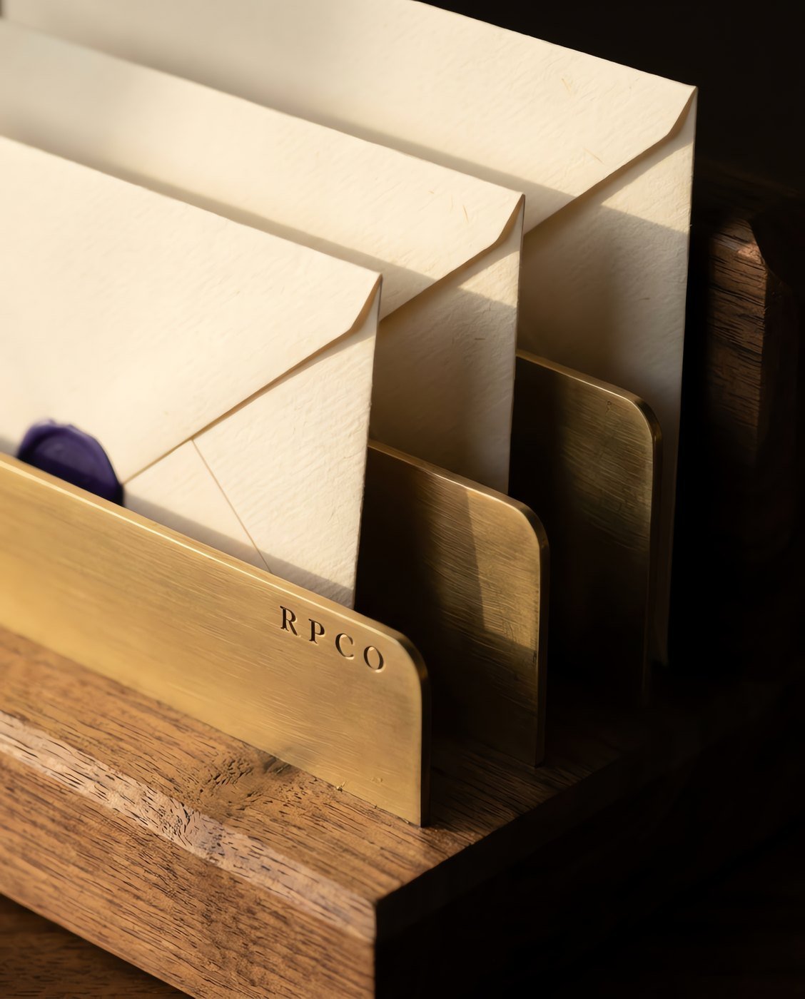 Letter Rack, Three Division — A walnut and brass three-division letter rack with rising dividers, holding cream envelopes at three different heights in close detail.