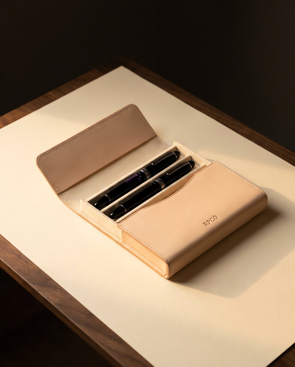 Pen Case, Two Pen — A hard-sided two pen case in pale undyed leather lying open to show two fountain pens separated by a felt-lined divider.