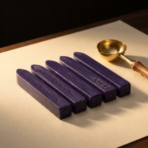 Sealing Wax Sticks, Registry Violet — Five sticks of deep violet sealing wax lying in a row on cream paper beside a brass melting spoon.